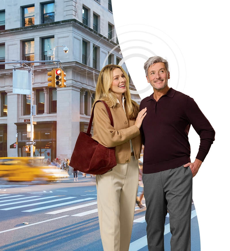 Pareja caminando y hablando en una gran ciudad.