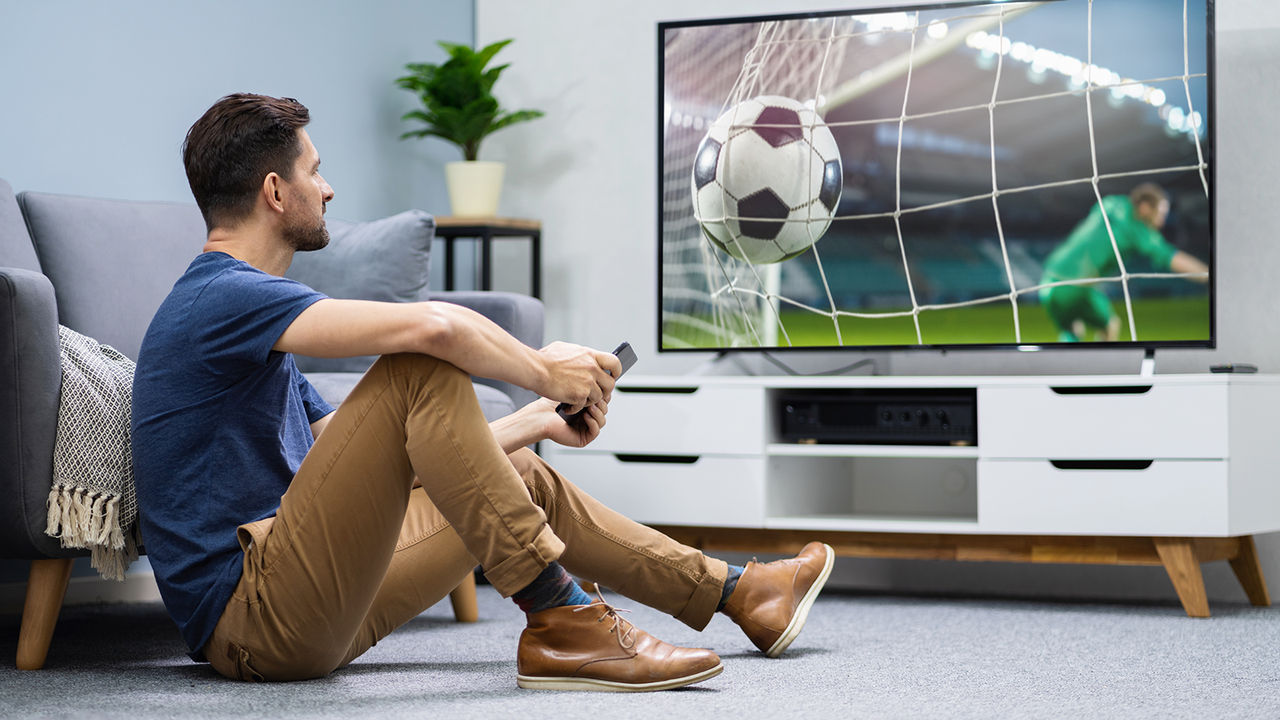 Pria menonton sepakbola di TV